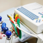 A medical technician prepares to use an ECG machine with electrode cables.