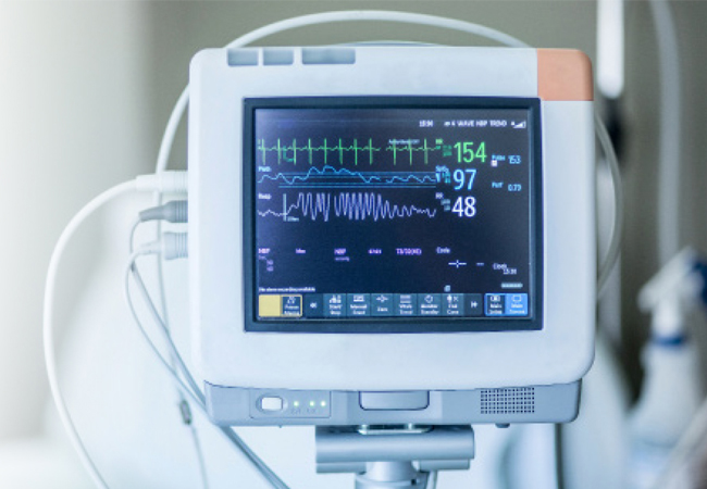 A medical monitor displaying vital signs in a hospital setting.